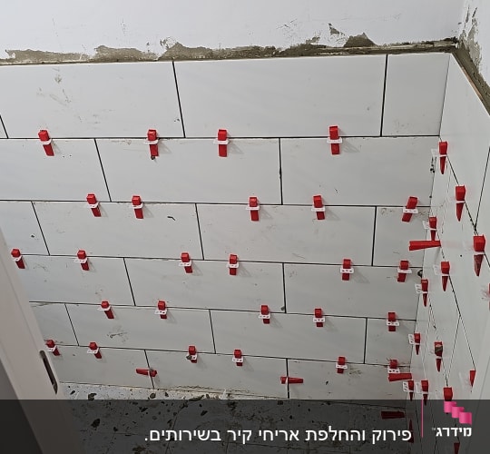 אריחים מותקנים עם תפסנים אדומים על קיר